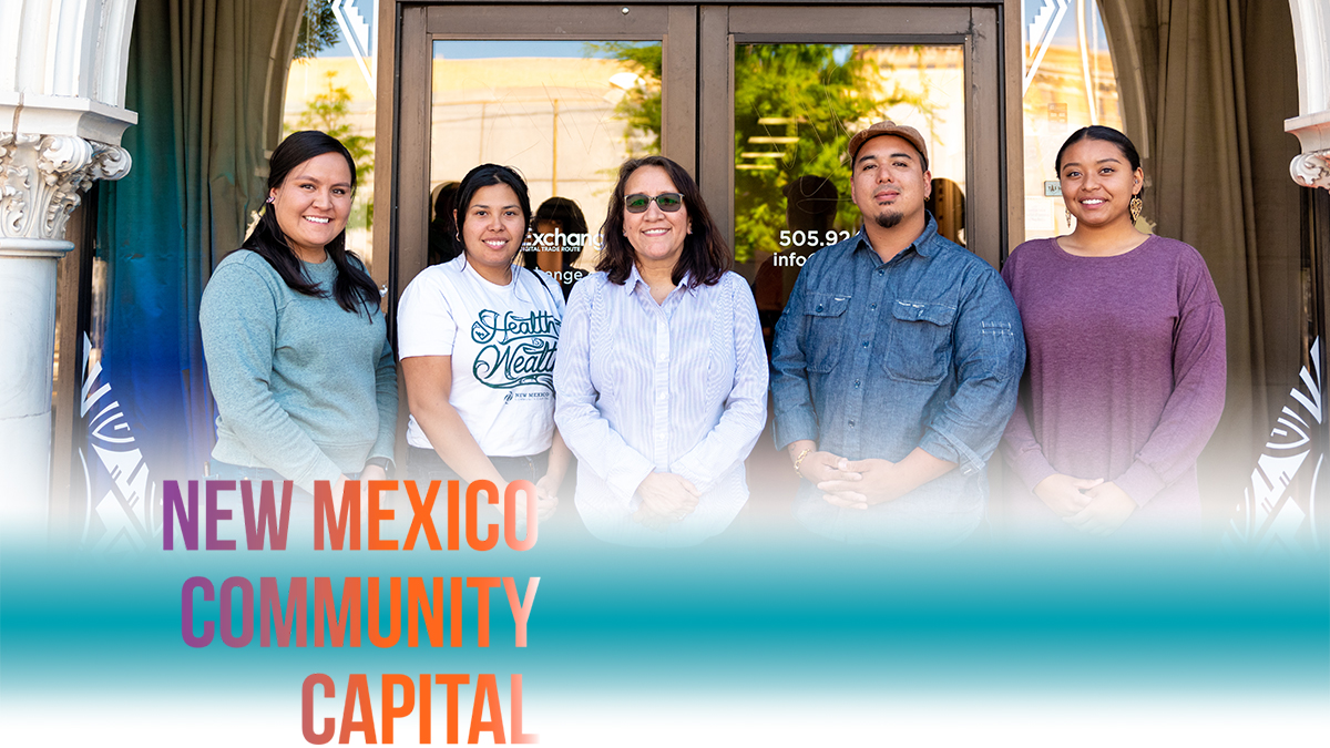 New Mexico Community Capital Staff standing together in front of the organization’s entrance.
